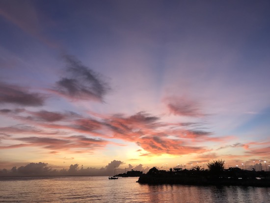 Pink and orange sunrise reflected on water in Honiara, Solomon Islands