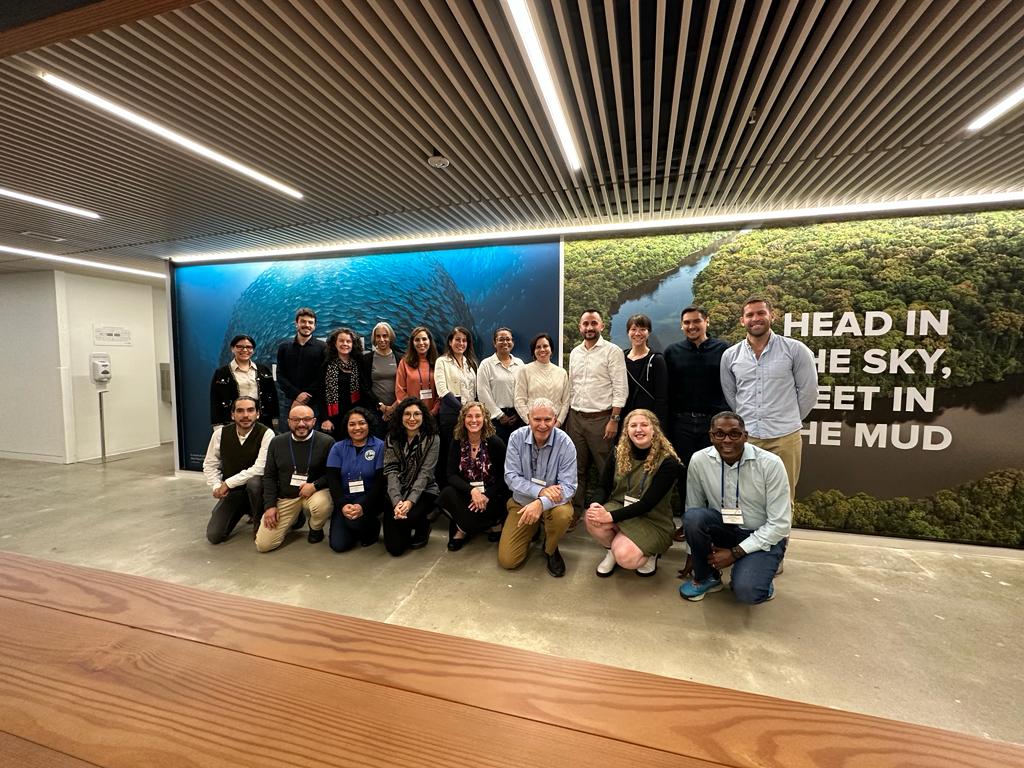Our Integrating Natural Capital into Investment Decisions participants, instructors, and staff smile together against a wall